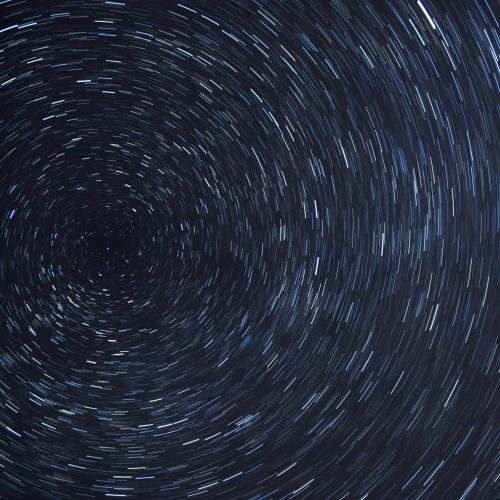 Dazzling star trails creating a spiral effect in the clear night sky.